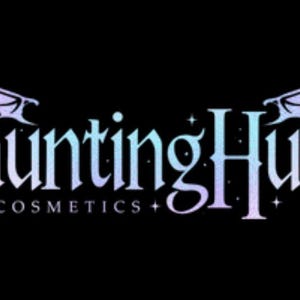 May include: A logo for a cosmetics company called "Haunting Hues Cosmetics". The logo features a gothic font with a gradient of purple and blue colors. The logo is framed by two stylized wings.