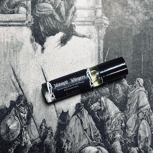 May include: A black roller bottle with a white label that reads "Midnight Whisper's Grave Dirt, Lily of the Valley & Elderflowers". The bottle is sitting on a black and white illustration of a scene with people and horses.