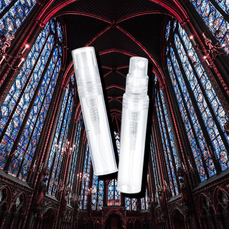 May include: Two clear plastic refillable spray bottles with a fine mist sprayer. The bottles are against a background of stained glass windows in a cathedral.