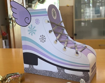 May include: A purple and white ice skate shaped party favor box with a silver glitter bottom. The box has a white wing on the side and a silver ribbon tied in a bow.