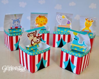 May include: Set of six colorful circus-themed favor boxes with animal characters. Each box features a red and white striped tent with a blue and black tent flap. The boxes are decorated with a variety of animals, including a monkey, a lion, an elephant, a giraffe, a hippopotamus, and a seal.