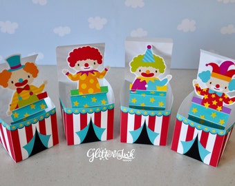 May include: Four colorful clown-themed party favor boxes with red and white striped sides and a blue tent flap. Each box features a different clown with a red, yellow, green, or purple costume.