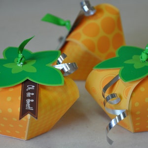 Puede incluir: Tres cajas de regalo naranja y verde con lunares blancos y un diseño de estrella verde. Las cajas tienen una cinta plateada y el texto "Oh, so sweet!" en una de las cajas.