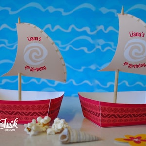 以下が含まれることがあります： 白い渦巻き模様と「Liana's 4th Birthday」の文字が描かれた茶色の帆が付いた、赤と白の紙製のパーティーのお土産用ボートが2つあります。