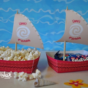 May include: Two red and white paper boats with a sail. The sail is decorated with a swirl design and the text "Liana's 4th Birthday". One boat is filled with popcorn and the other with candy.