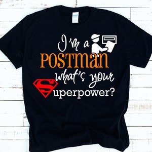 Puede incluir: Camiseta negra con texto blanco que dice "Soy cartero, ¿cuál es tu superpoder?" con un logotipo de Superman rojo y una pequeña ilustración en blanco y negro de un cartero entregando correo.