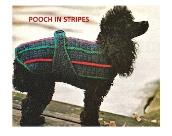 Op de afbeelding: Een zwarte hond draagt een gebreide trui met blauwe, groene en rode strepen. De trui heeft een label met de tekst "POOCH IN STRIPES".