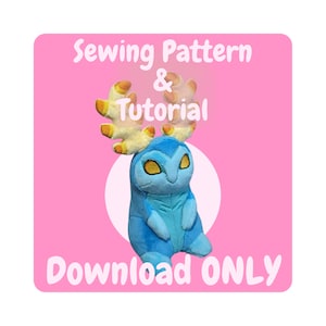 May include: A pink square with white text that reads "Sewing Pattern & Tutorial Download ONLY". A blue plush toy with yellow antlers is in the center of the square.