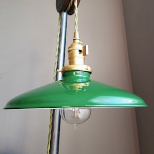 May include: A green metal lampshade with a brass socket and a vintage-style light bulb hanging from a rope pulley system.