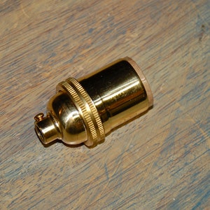 May include: A gold-colored metal light bulb socket.