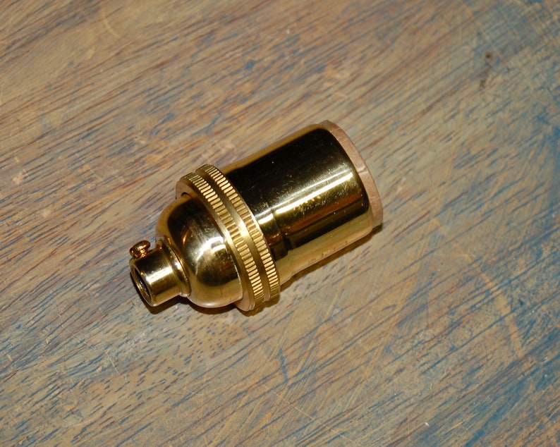 May include: A gold-colored metal light bulb socket.