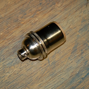 May include: A silver light bulb socket with a threaded end.