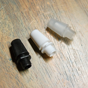 May include: Three cable connectors, one black, one white, and one clear, on a wooden surface.