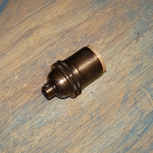 May include: A brass light bulb socket with a threaded end for attaching to a wire.