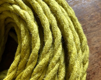 May include: Close-up of a coiled length of bright yellow braided cord. The cord is made of a soft, textured material and has a slightly fuzzy appearance.