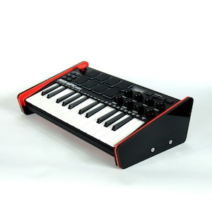May include: A black and red AKAI MPK Mini MIDI keyboard with white keys and black pads and knobs. The keyboard is on a black stand with red trim. The product is designed for music production and performance.