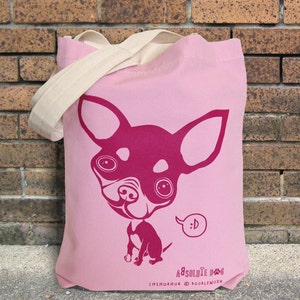 May include: Pink tote bag with a magenta illustration of a Chihuahua dog. The dog has large eyes and a speech bubble with a smiley face. The bag has cream-colored handles and the text "Absolute Dogs" and "Chihuahua @ Doodleworm".