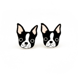 Könnte beinhalten: Ein Paar Ohrstecker in Form eines Boston Terrier Hundekopfes. Die Ohrringe sind in Schwarz und Weiß gehalten, mit rosafarbenen Innenohren, großen kreisförmigen Augen und einem markanten weißen Streifen, der von der Stirn bis zur Schnauze verläuft.