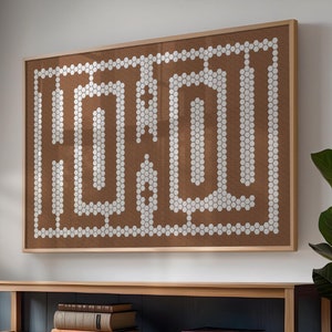 May include: A wooden shelf unit with two shelves, featuring a brown corkboard with the word "HOME" spelled out in white circles. The shelf is holding books, including "The Great Gatsby" and "The Seven Husbands of Evelyn Hugo".