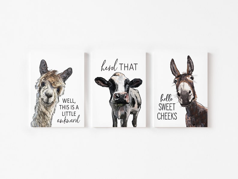 May include: Three framed prints with illustrations of a llama, a cow, and a donkey. The llama is looking at the camera with the text "Well, this is a little awkward". The cow is looking at the camera with the text "herd that". The donkey is looking at the camera with the text "hello sweet cheeks".