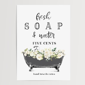 May include: A black and white sign with the text "fresh SOAP & water FIVE CENTS" and a drawing of a gray bathtub with white flowers. The text "hand towels extra" is at the bottom of the sign.