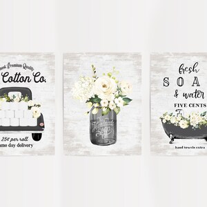 May include: Three vintage-style prints with a farmhouse theme. The first print features a black pickup truck with white flowers and toilet paper rolls. The second print features a mason jar with white flowers. The third print features a black bathtub with white flowers and the text "fresh SOAP & water FIVE CENTS hand towels extra".