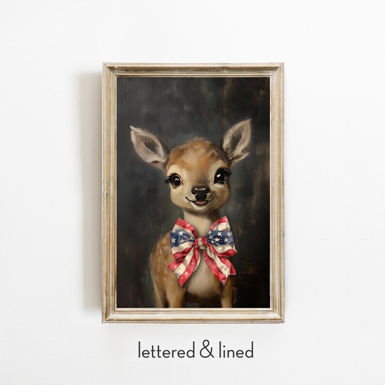 Puede incluir: Pintura enmarcada de un cervatillo con una pajarita con los colores de la bandera estadounidense. La obra de arte tiene un marco de madera clara y un fondo oscuro. El texto "lettered & lined" est&aacute; en la parte inferior de la imagen. El cervatillo tiene ojos grandes.