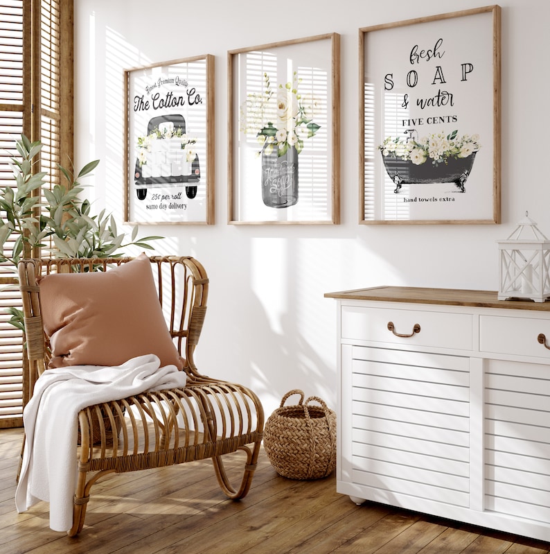 May include: Three framed prints with a farmhouse theme. The first print features a vintage truck with the text "The Cotton Co. 25&cent; per roll same day delivery". The second print features a mason jar filled with white flowers. The third print features a vintage bathtub with the text "Fresh Soap & Water Five Cents Hand towels extra".