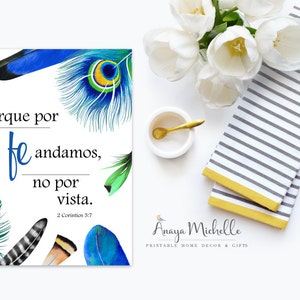 May include: A white print featuring the text "Porque por fe andamos, no por vista" with watercolor feathers in blue, green, and brown. The print is accompanied by a striped towel, flowers, and gold spoon.