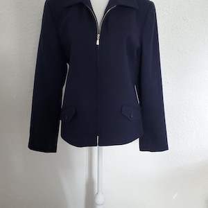May include: A navy blue zip-up jacket with a stand-up collar and two pockets on the front.