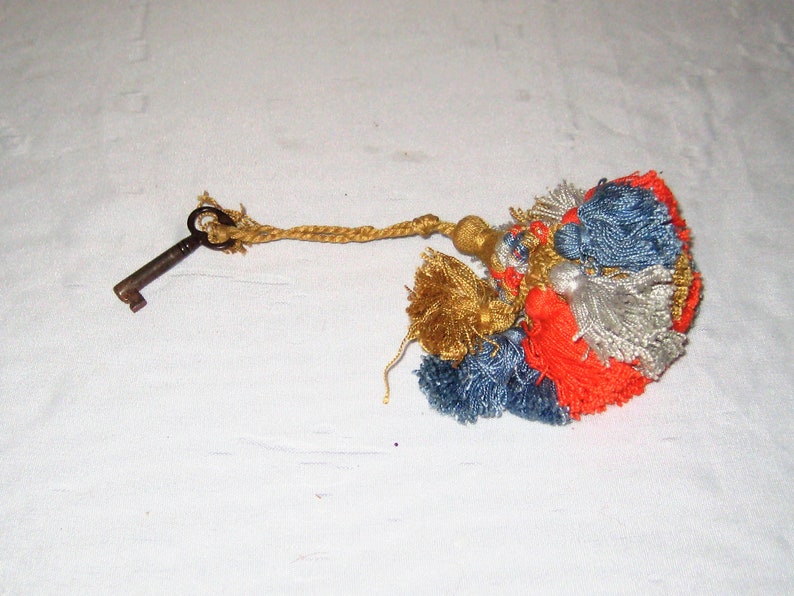 vintage orange old clock key gold tassel blue gray Skeleton key on ornate tassle antique