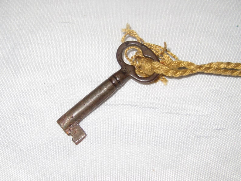 vintage orange old clock key gold tassel blue gray Skeleton key on ornate tassle antique