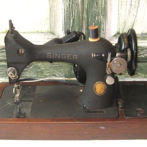 Antieke elektrische Singer-naaimachine, bruine houten koepelvormige kast, zwartgouden gietijzeren metalen naaimachine, draagbare reizende halverwege de jaren 50