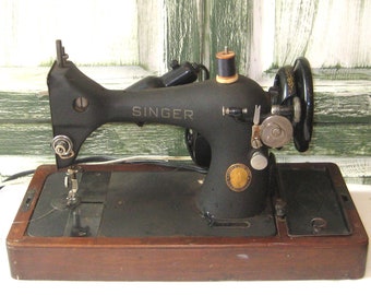 Antieke elektrische Singer-naaimachine, bruine houten koepelvormige kast, zwartgouden gietijzeren metalen naaimachine, draagbare reizende halverwege de jaren 50