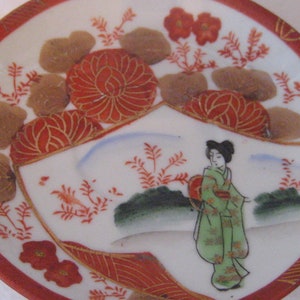 Asian tea cup and saucer, porcelain, geisha girl, orange green white gold, Chinese characters, Japanese Oriental teacup, chinoiserie chic