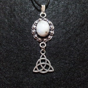 May include: A silver necklace featuring a white moonstone pendant and a silver Celtic knot charm.
