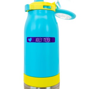 May include: A blue and yellow water bottle with a stainless steel bottom. The bottle has a heart and the name "ADLEY MEYER" on a purple label.