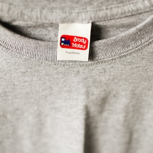 May include: A white tearaway label with red text that reads "Brody Matsui" and a small blue train graphic. The label says "Tearaway" below the text.