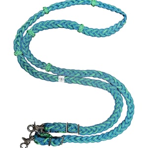 May include: A pair of braided turquoise and green leather reins with silver snap hooks. The reins are braided with a decorative pattern.