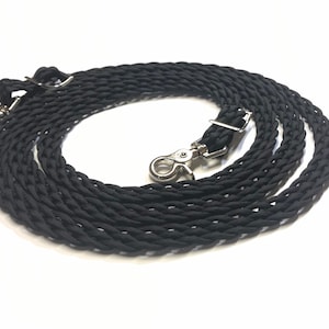 May include: Black braided leather reins with silver snap hooks. The reins are coiled and ready for use.