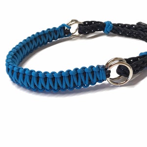 May include: A blue and black braided dog collar with two silver metal rings.