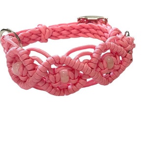 May include: Pink macrame dog collar with a braided design and decorative accents. The collar features three light pink, round beads and silver-colored hardware. A stylish accessory for pets.