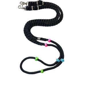 May include: Black braided leather reins with colorful knots. The reins have two sets of silver snaps.