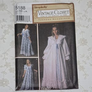 May include: A Simplicity 5188 sewing pattern envelope for a Vintage Closet gown by Theresa Nordstrom. The package displays three variations of a floor-length dress with ruffled collars, long sleeves, and front ribbon ties in floral and solid fabrics.