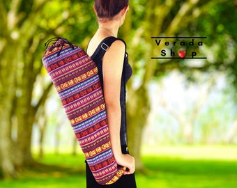 May include: A person wearing a black tank top and carrying a colorful yoga mat bag with a drawstring closure and adjustable shoulder strap. The bag has a vibrant pattern with red, yellow, blue, and green stripes. The text "Verada Shop" is visible in the background.