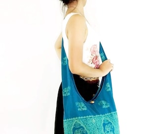 Puede incluir: Un bolso de hombro azul turquesa con un diseño de estampado de elefante. El bolso tiene un cierre de cordón y una correa larga.