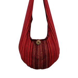 Pu&ograve; includere: Una borsa hobo a righe rosse e nere con una chiusura a bottone decorativa. La borsa &egrave; realizzata in tessuto morbido e tessuto.