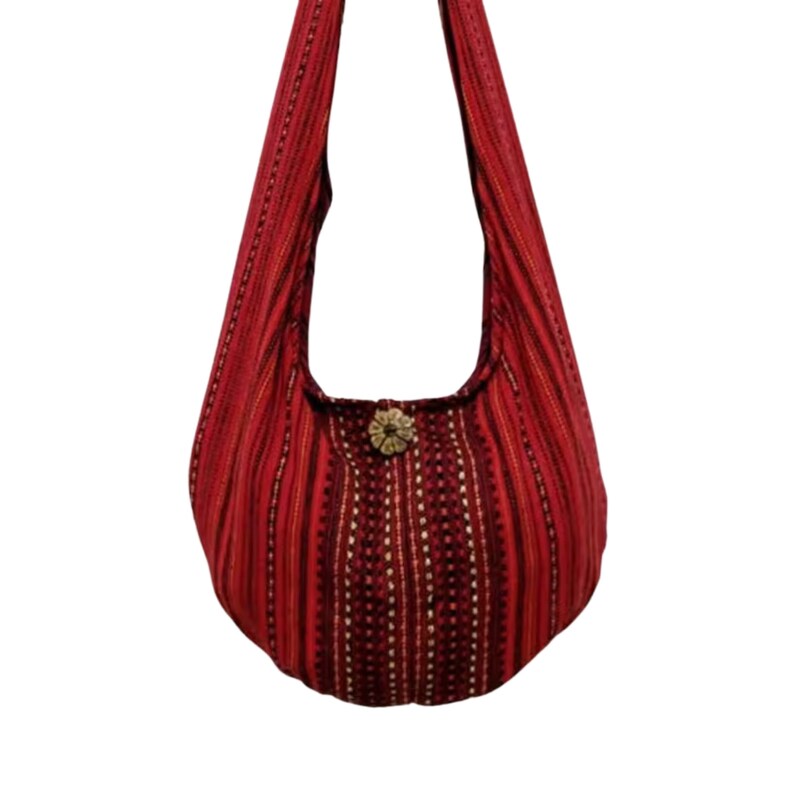 Pu&ograve; includere: Una borsa hobo a righe rosse e nere con una chiusura a bottone decorativa. La borsa &egrave; realizzata in tessuto morbido e tessuto.