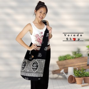 Può includere: Una borsa tote in cotone nero e bianco con un design a forma di elefante. La borsa ha una tracolla lunga e si porta sulla spalla. La borsa è realizzata in Thailandia.