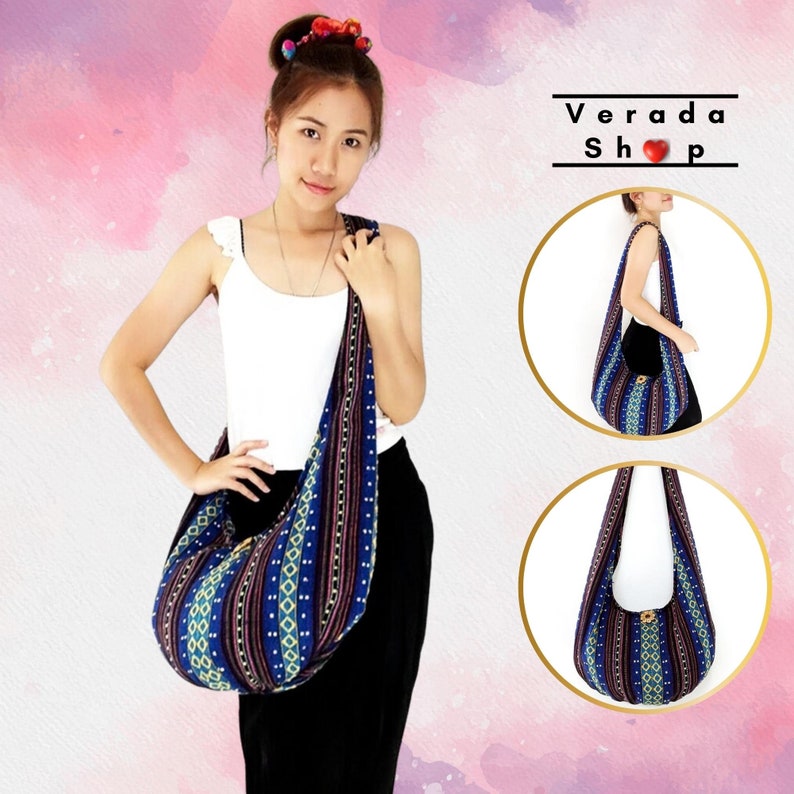 May include: A blue and purple patterned hobo bag with a long strap. The bag is worn by a person with long dark hair. The bag has a geometric pattern with yellow, white, and red accents. The text "Verada Shop" is visible in the image.